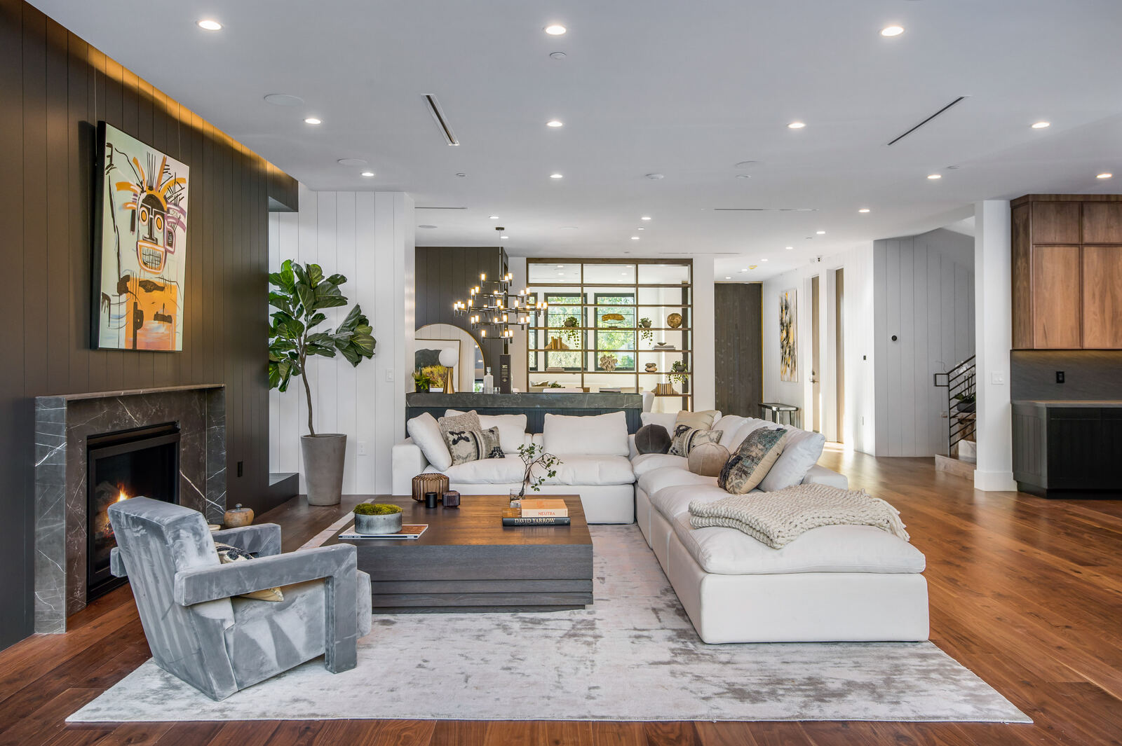 Open Van Nuys living room with white sectional and glass shelving